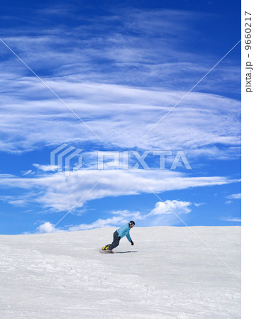 Snowboarder on ski slope and blue sky with clouds 9660217