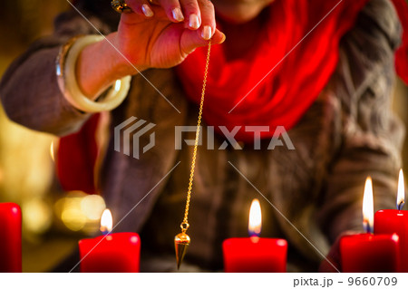 Soothsayer during a Seance or session with pendulum Soothsayer during a Seance or session with pendulum 9660709