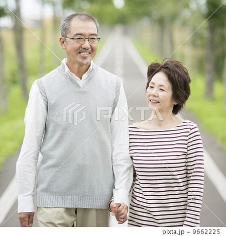 手をつなぎ一本道を歩くシニア夫婦 手をつなぎ一本道を歩くシニア夫婦 9662225