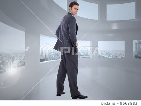 Composite image of serious businessman with hands on hips Composite image of serious businessman with hands on hips 9663883