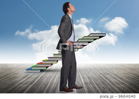 Composite image of serious businessman with hands on hips Composite image of serious businessman with hands on hips 9664040