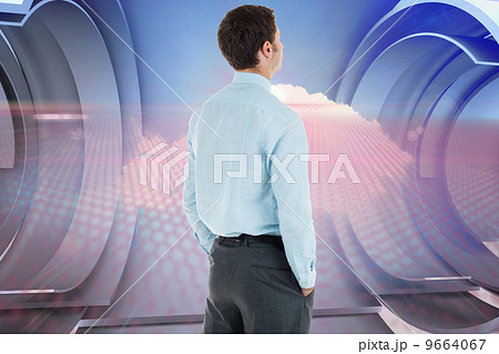 Composite image of serious businessman standing with hands in po 9664067