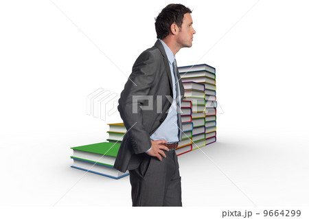 Composite image of serious businessman with hands on hips 9664299