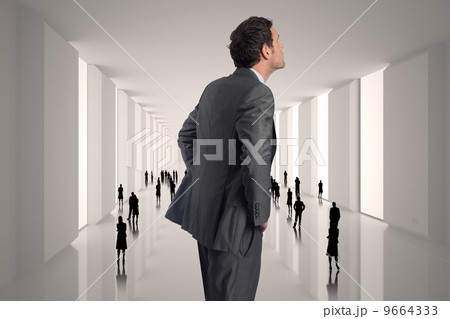 Composite image of serious businessman with hands on hips Composite image of serious businessman with hands on hips 9664333