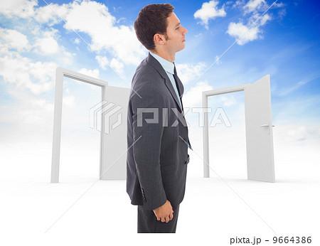 Composite image of serious handsome businessman standing 9664386