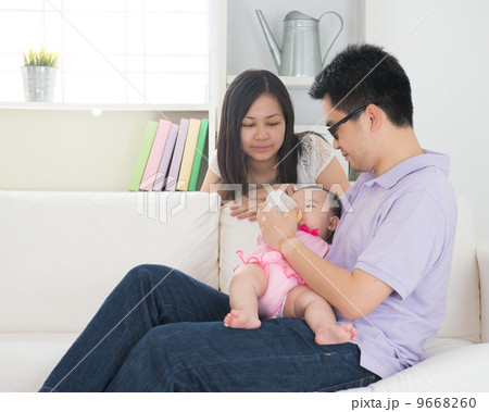 chinese asian parents feeding baby boy at home 9668260