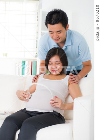 chinese husband listening to his wife's stomach 9670210