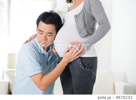 chinese husband listening to his wife's stomach chinese husband listening to his wife's stomach 9670232