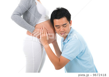 Husband listening to his wife's belly at home Husband listening to his wife's belly at home 9672418