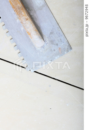 building work tool dirty trowel on new tile floor surface 9672948