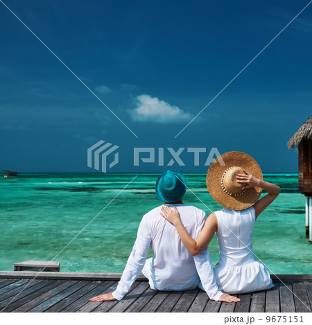 Couple on a beach jetty at Maldives 9675151