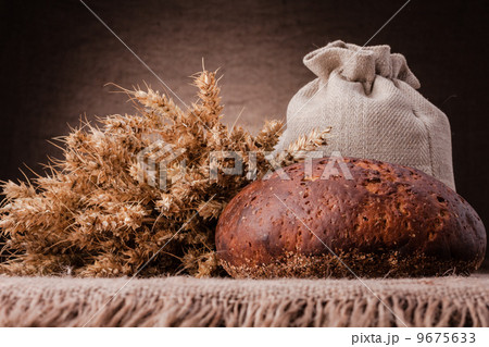 Loaf of bread and rye ears still life 9675633