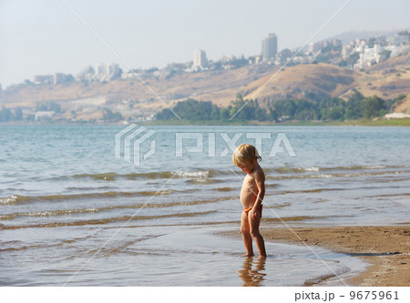 Child on the shore of lake Kinneret in the morning 9675961
