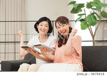 タブレットを持ってガッツポーズする女性 9676918