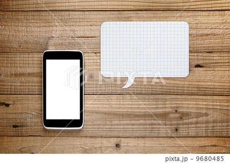 Smartphone with speech bubble on wooden background 9680485