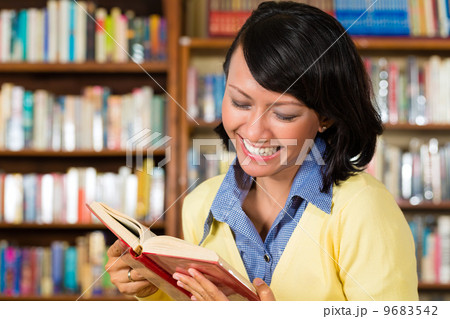 Asian girl in library reading a book 9683542