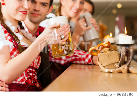 Young people in traditional Bavarian Tracht in restaurant or pub 9683590