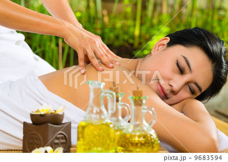 Asian woman having a massage in tropical setting 9683594