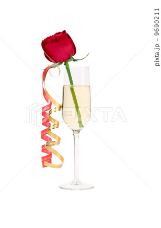 Red rose in glass of champagne and paper streamer. Red rose in glass of champagne and paper streamer. 9690211