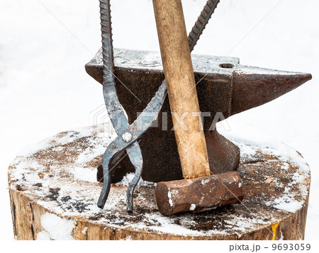 anvil, blacksmith tongs and hammer in smithy 9693059