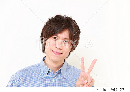 ピースサインを出す男性の写真素材