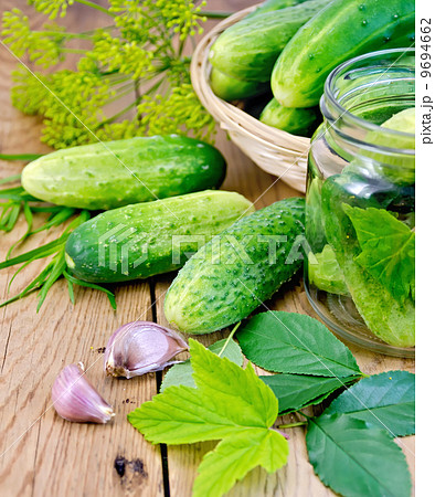 Cucumbers in jar and a wicker basket with leaves 9694662
