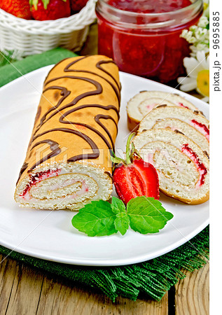 Roulade with jam and strawberries on a board 9695885
