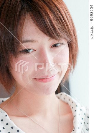 照れ笑い 幸福 若い女性の表情 感情 コスメ美容イメージ 美人 代 色白 スタジオ撮影の写真素材