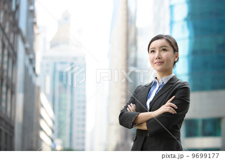 Successful business woman outdoor folding arms in front of glass building shallow depth of field Successful business woman outdoor folding arms in front of glass building shallow depth of field 9699177