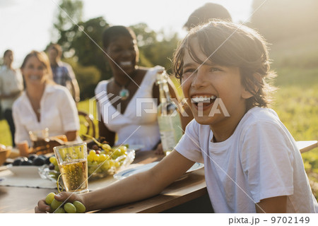 A family and friends having a meal outdoors. A picnic or buffet in the early evening. 9702149