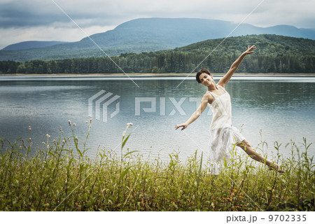 A woman dancing gracefully in the open air along the lake shore near Woodstock, New York State, USA 9702335