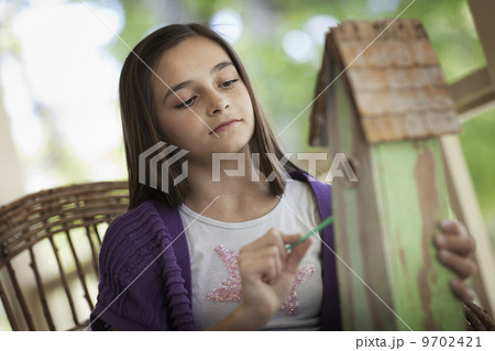 A child examining a bug box on a porch. 9702421