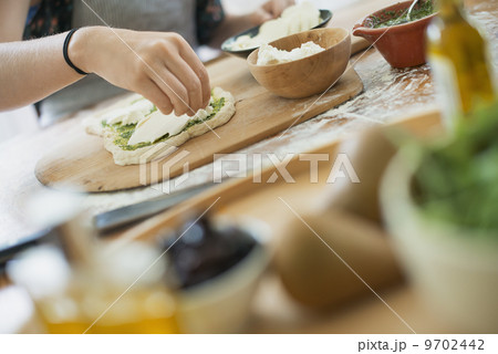 A person making a wrap with fresh ingredients and green salsa. A person making a wrap with fresh ingredients and green salsa. 9702442