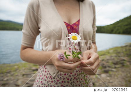 A woman in open countryside, by a mountain lake. A woman in open countryside, by a mountain lake. 9702545