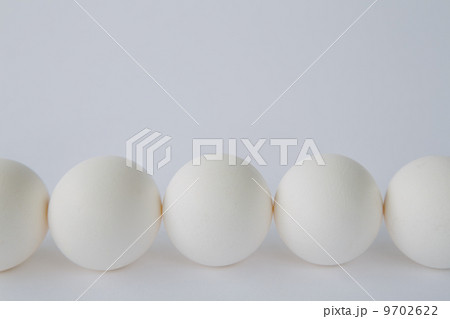 End-on view of free range, organic eggs with white shells arranged in a row, on a white background. End-on view of free range, organic eggs with white shells arranged in a row, on a white background. 9702622