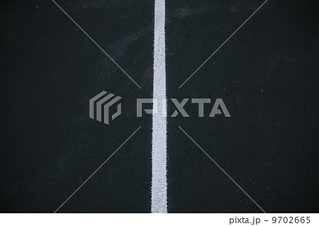 White center line on a black asphalt surface. 9702665