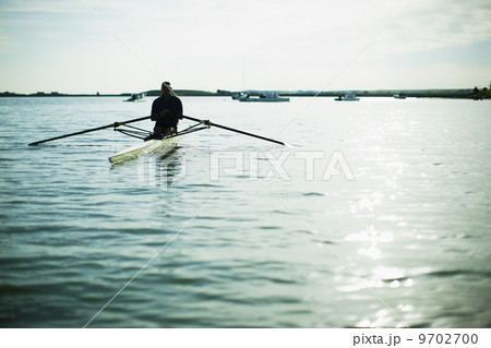 A middle-aged man in a rowing boat on the water. 9702700