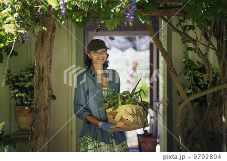 A young woman in a farmhouse kitchen, with large windows onto the garden. A young woman in a farmhouse kitchen, with large windows onto the garden. 9702804