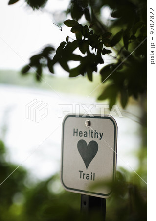 A health trail information sign, a metal marker path sigh with an image of a green heart. A health trail information sign, a metal marker path sigh with an image of a green heart. 9702822