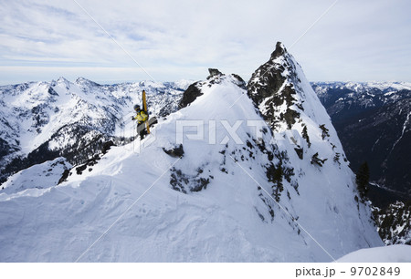 A skier stands on a ridgeline before skiing The Slot on Snoqualmie Peak in the Cascades range, Washington state, USA. A skier stands on a ridgeline before skiing The Slot on Snoqualmie Peak in the Cascades range, Washington state, USA. 9702849