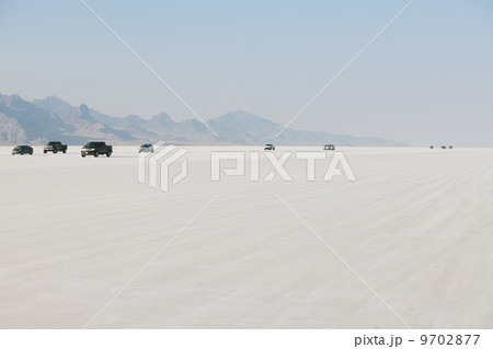 Cars driving on Bonneville Salt Flats during Speed Week. Dusk. Cars driving on Bonneville Salt Flats during Speed Week. Dusk. 9702877
