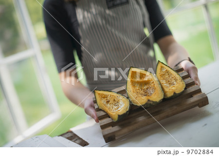 A person holding a tray of organic grilled vegetables, squash or pumpkin. A person holding a tray of organic grilled vegetables, squash or pumpkin. 9702884