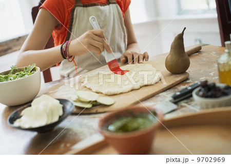 A person making a wrap with fresh ingredients and green salsa. A person making a wrap with fresh ingredients and green salsa. 9702969