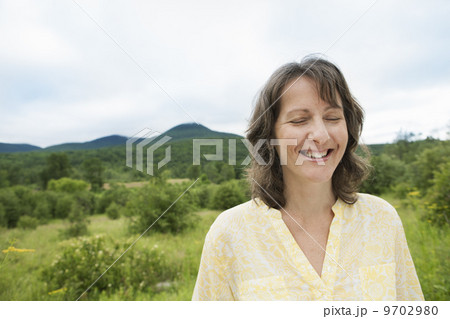 A woman in open countryside, by a mountain lake. 9702980