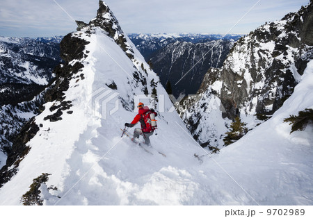A skier ski-ing down The Slot snow slope on Snoqualmie Peak in the Cascades range, Washington state, USA. 9702989