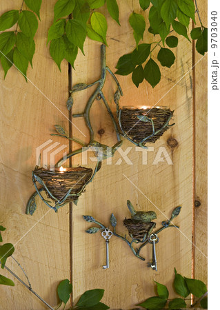 Three candle sconces on a wall, with lit tea lights, and a climbing vine. Three candle sconces on a wall, with lit tea lights, and a climbing vine. 9703040