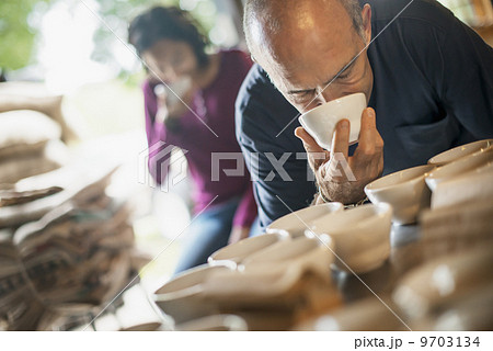 The sampling procedure in a coffee processing shed, where staff make coffee in small pots and sample the taste to test the blend. 9703134