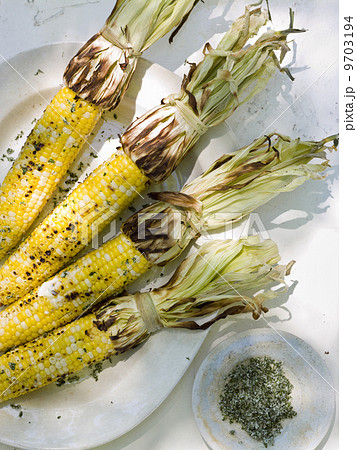 A buffet table set up in a garden for al al fresco meal. Sweetcorn, corn on the cob. 9703194