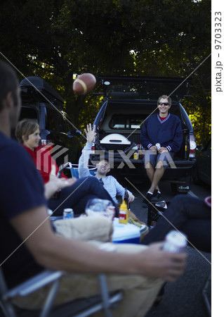 A group of friends at a barbeque or tailgate party at an event. A group of friends at a barbeque or tailgate party at an event. 9703323