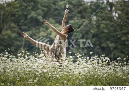 A woman dancing in a field of wild flowers. 9703367